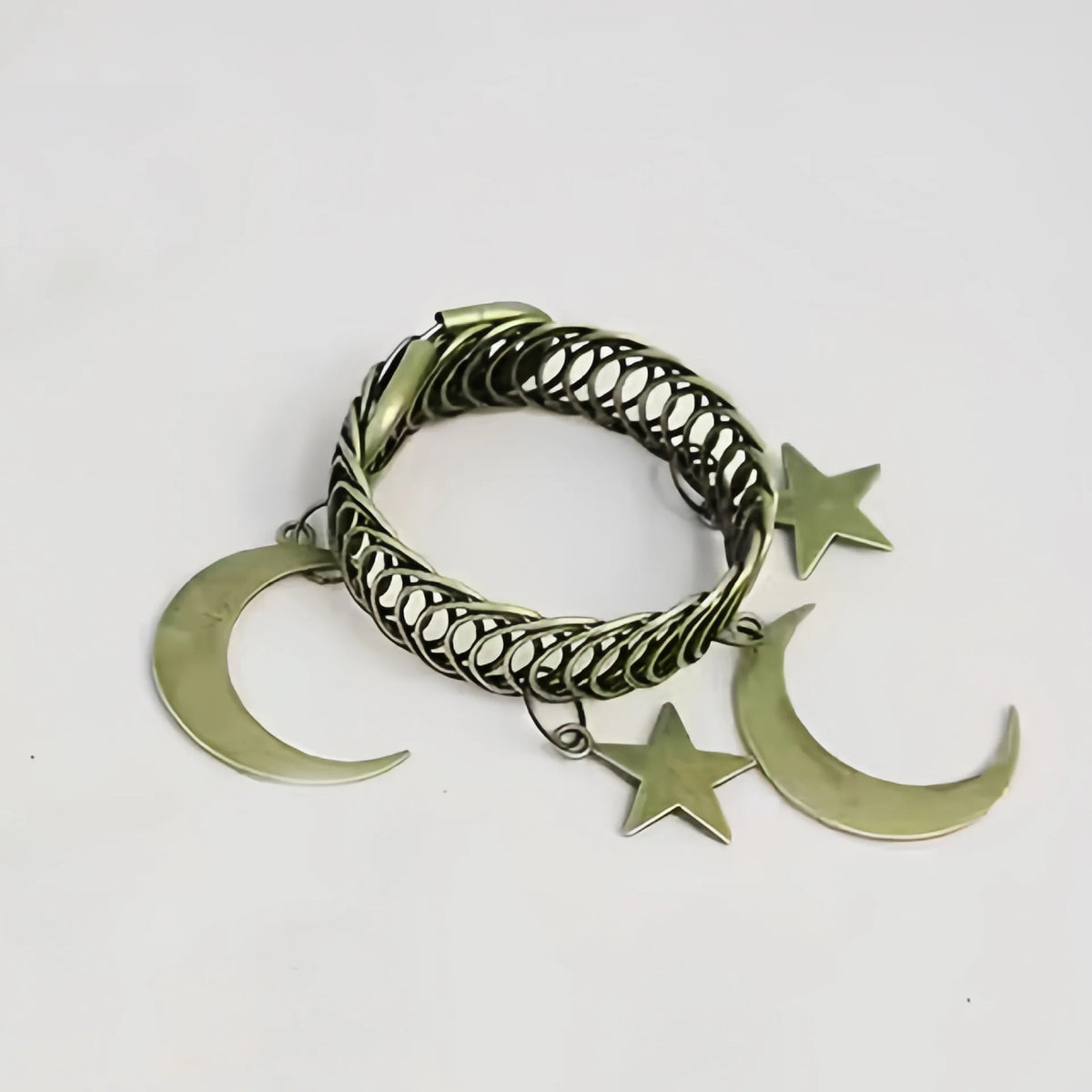 A set of two vintage metal curtain clips featuring a braided crescent moon and a star shape.