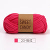A skein of bright pink hand-dyed yarn labeled Sweet Candy Yarns.