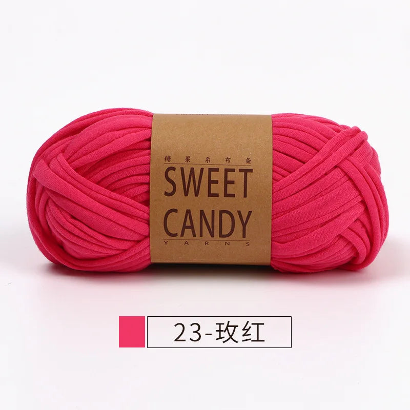 A skein of bright pink hand-dyed yarn labeled Sweet Candy Yarns.