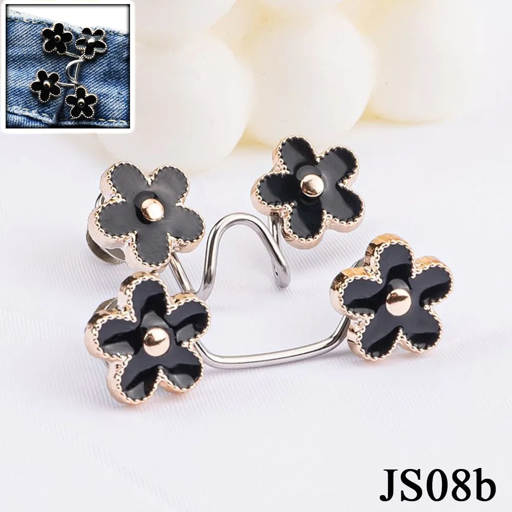 Silver and gold floral button clips used for adjusting jeans waist tightness.