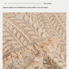 Close-up of a beige and cream textured fabric showing herringbone weave detail.