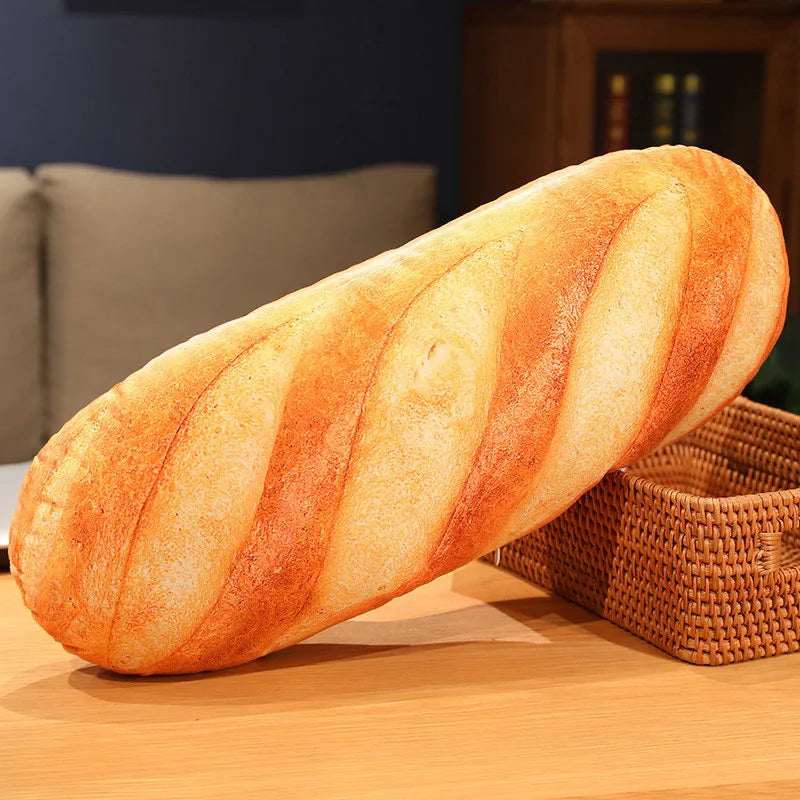 A loaf of golden-brown French bread with striped scoring is shown resting on a wooden surface.