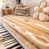 A beige and white cow print plush velvet sofa protector cover with matching throw pillows.