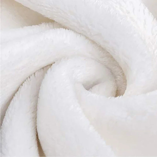 A close-up of a white, fluffy flannel throw blanket rolled into a spiral.