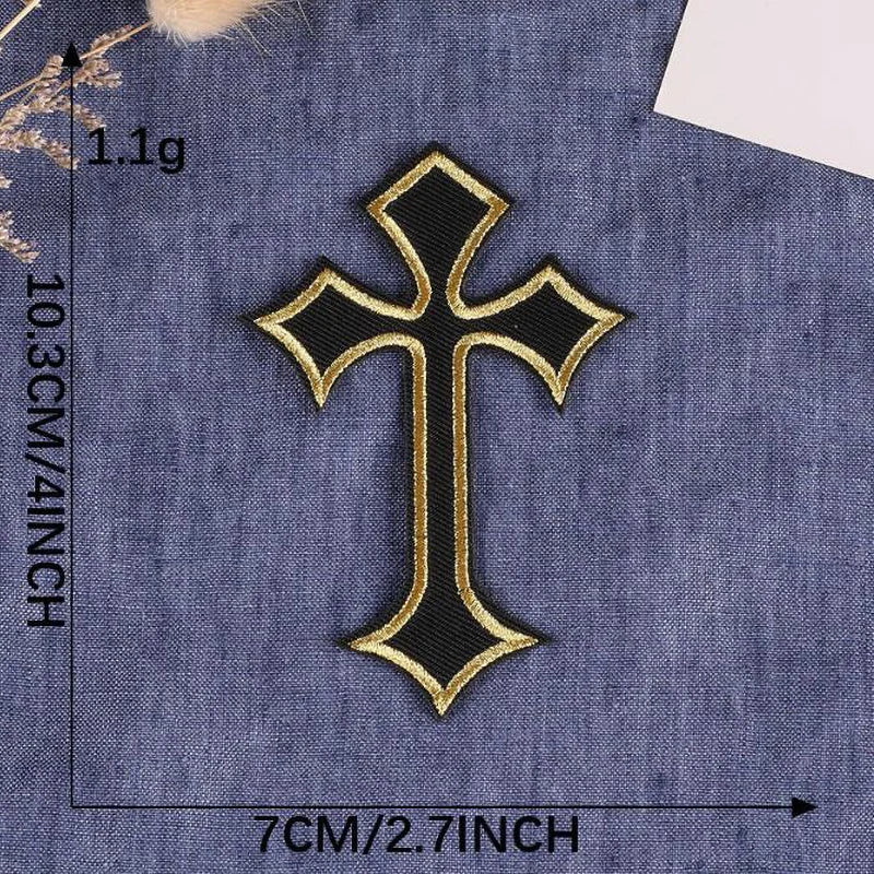A black and gold cross embroidery patch on a blue fabric background.