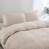 A beige boho tufted microfiber duvet cover set with matching pillows on a bed.