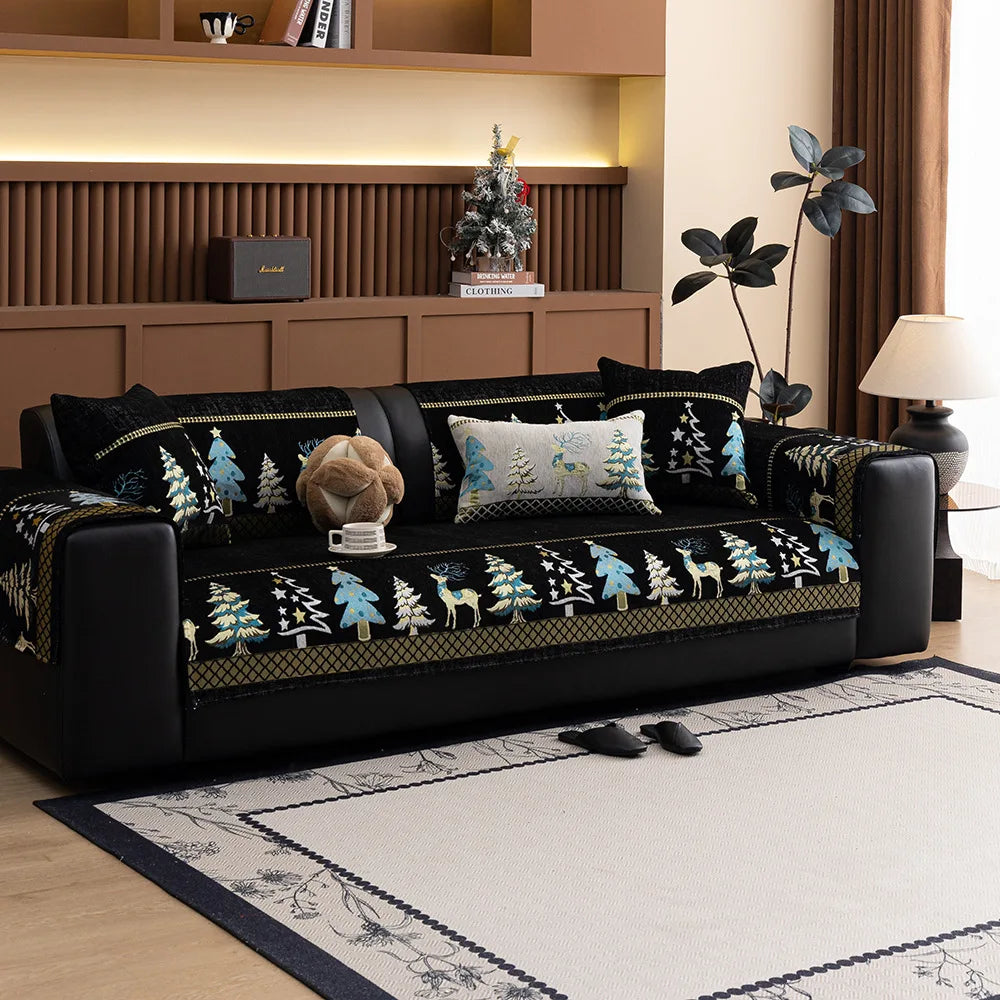 A black sofa with a deer and Christmas tree pattern mat cover sits in a modern living room.