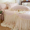 A pink and cream Korean style lace embroidered duvet set displayed on a bed with sheer fabric layers.