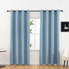 Light blue blackout curtains hanging on a rod in a bright room.
