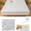 White brushed elastic fitted bed sheet set displayed on a wooden bed frame.