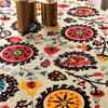 Close-up of a Bohemian printed linen fabric featuring floral patterns and brass candle holders.