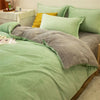 A light green duvet cover set featuring a soft gray flannel throw and matching pillows on a bed.