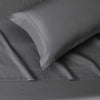 A close-up view of a smooth gray microfiber flat fitted sheet with a neatly folded corner.
