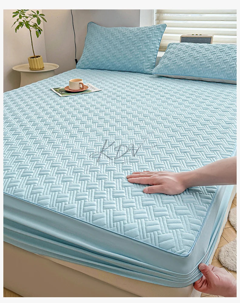 Light blue cooling spandex fitted sheet mattress protector laid out on a bed.