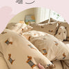A close-up of a beige duvet cover featuring a cute dog print, being held by a hand.