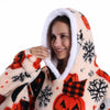 A woman smiling while wearing an oversized patchwork fleece hoodie with a white sherpa hood featuring orange and black season