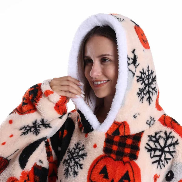 A woman smiling while wearing an oversized patchwork fleece hoodie with a white sherpa hood featuring orange and black season