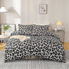A luxury leopard print duvet cover set displayed on a bed with modern lighting and wall art.