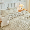 A beige embossed floral duvet cover set with matching pillowcases displayed on a bed.