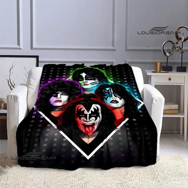 A black printed flannel travel blanket featuring four stylized women with dark hair and dramatic makeup.
