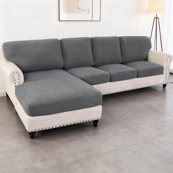 A modern gray sofa with white trim and seat cushions in a living room setting.