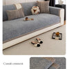 A gray sofa cushion cover with beige accents and a textured fabric displayed on a light carpet.