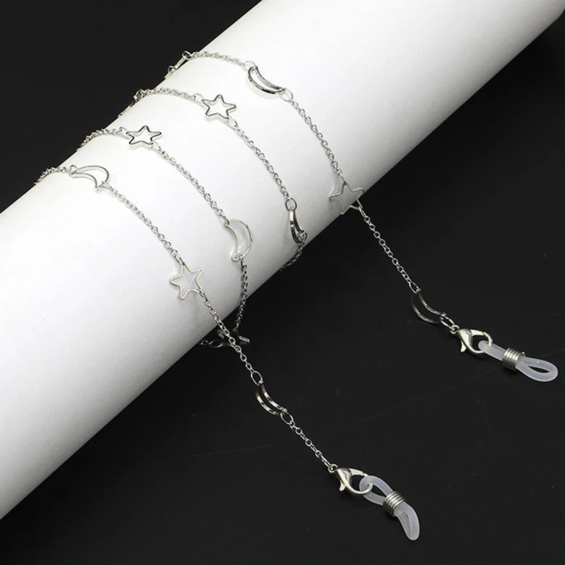 Silver star and moon charm necklace displayed on a white wrist.
