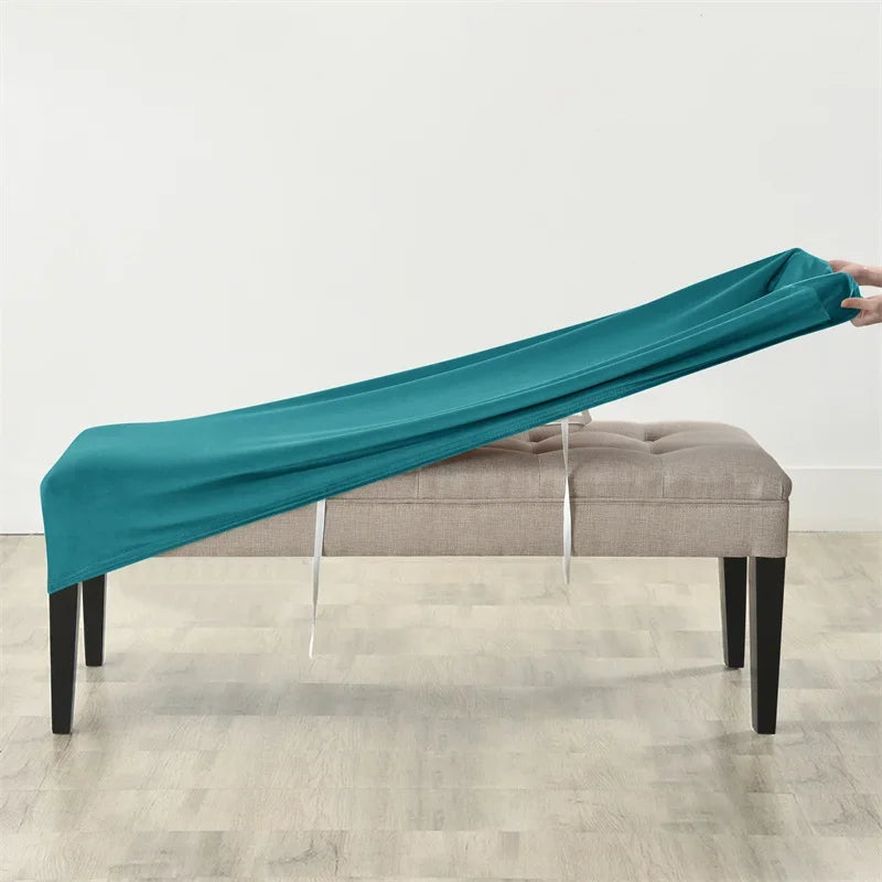 Teal velvet bench slipcover draped over a light gray upholstered bench.