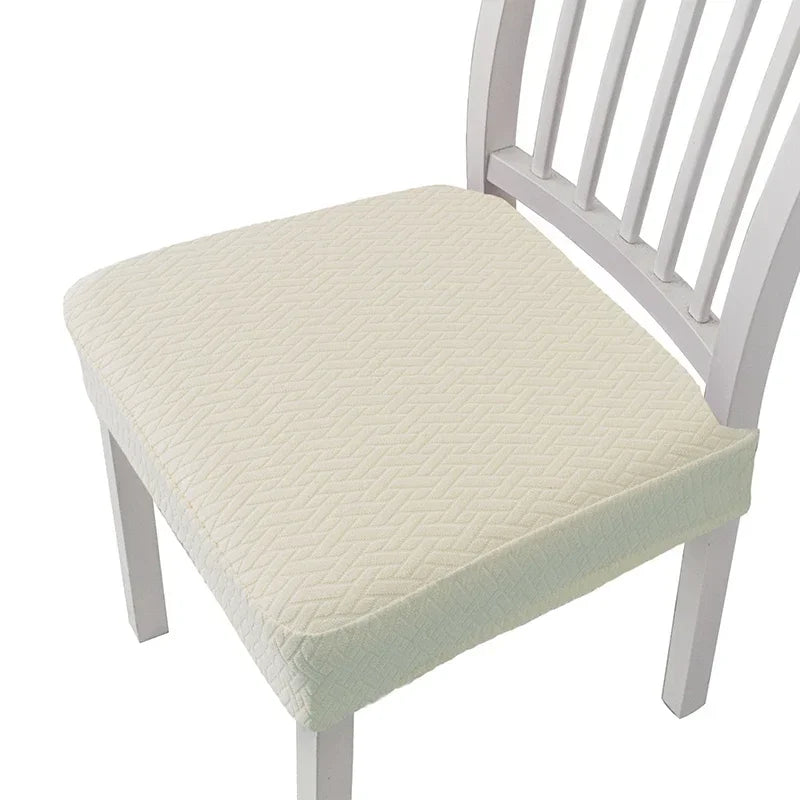 A white wooden dining chair with a light cream upholstered seat cover.