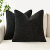 Three black linen textured throw pillows resting on a white sofa.