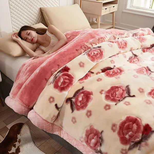 A pink and cream floral patterned weighted blanket is displayed on a bed with light bedding.