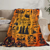 A cozy flannel throw blanket featuring Halloween-themed designs like witches pumpkins and bats on an orange background.