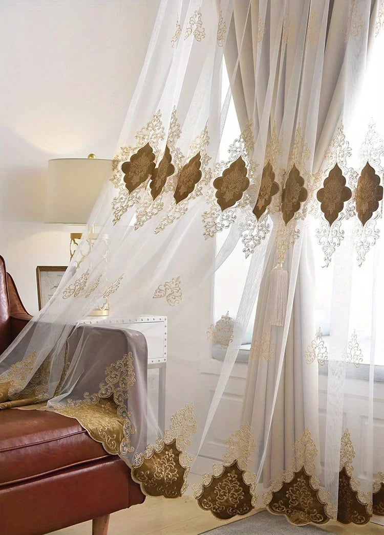 Sheer white and beige gauze curtains with gold embroidery framing a window.