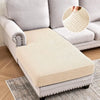 A beige stretch sofa cushion cover placed on a light gray sofa, showing the woven texture.