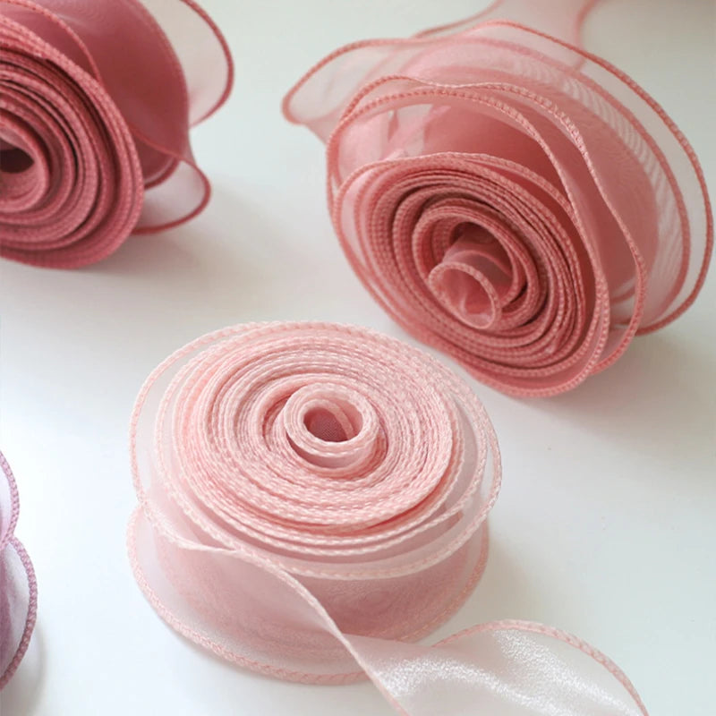 Pink wavy edge organza ribbon rolled into decorative roses for crafting