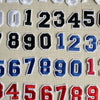 A collection of customizable number patches in black, white, and blue are displayed on a light background.