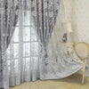 Gray vintage floral blackout curtain covering a window with sheer overlay