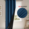 A dark blue blackout curtain hanging on a rod in a window frame.