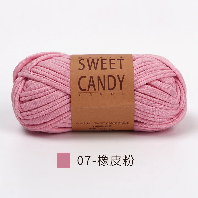 A skein of pink sweet candy yarn is shown lying horizontally against a white background.