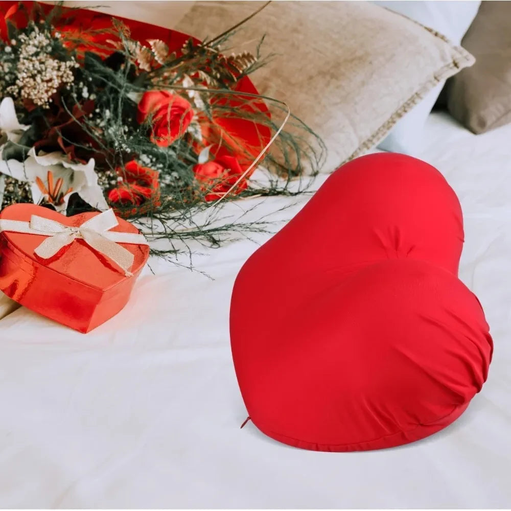 A bright red memory foam contour chest pillow resting on white fabric next to a floral arrangement and a gift box.