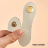 A set of eight light beige leather bag buttons, some with gold accents, being held by a hand.