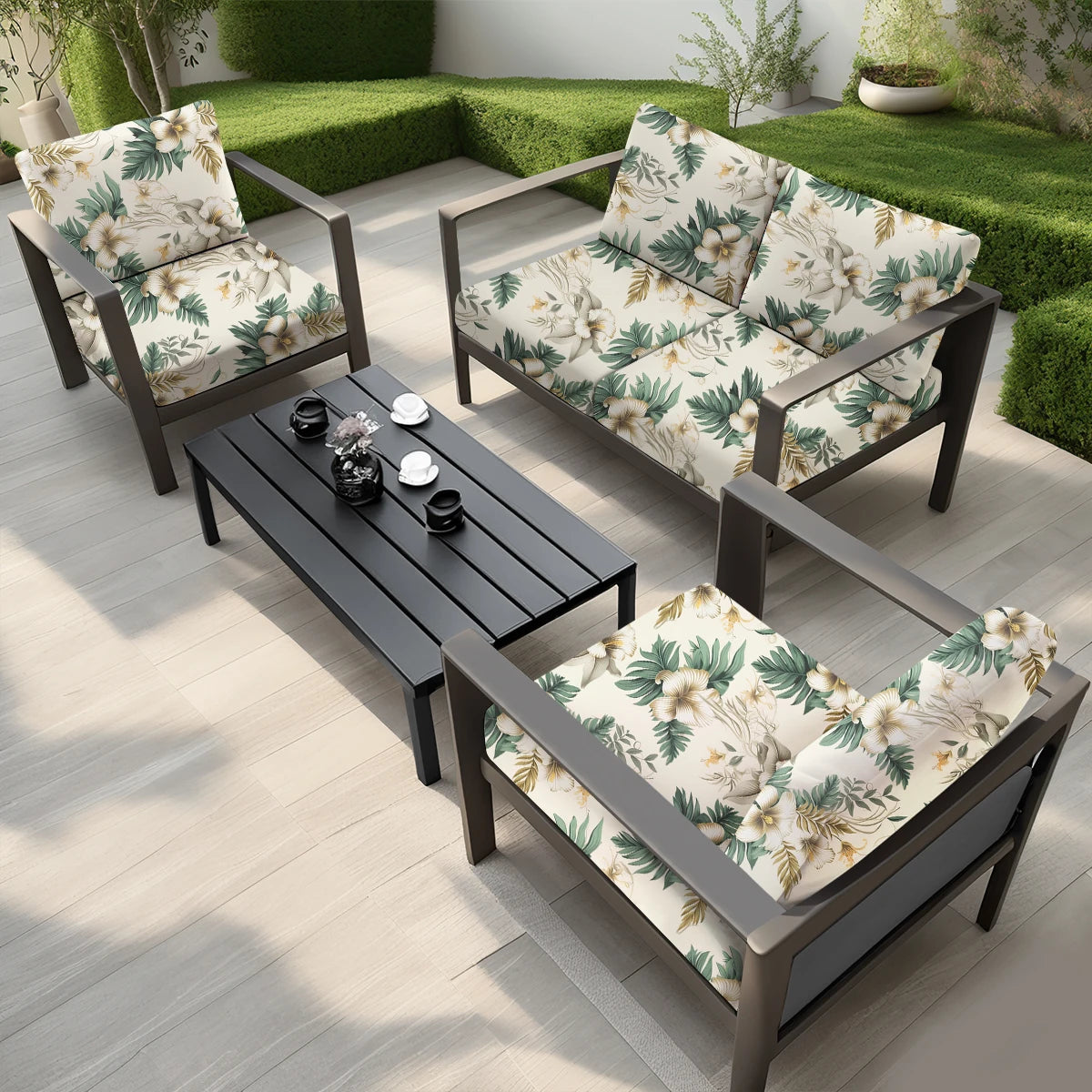 A dark outdoor sofa set with floral patterned cushions placed on a wooden deck.