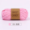 Pink sweet candy yarn skein with a brown label and a small tag indicating 05-gauge knitting needles.