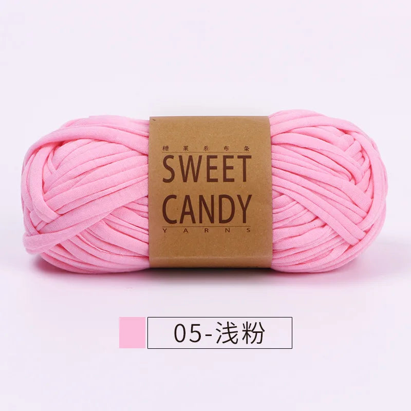 Pink sweet candy yarn skein with a brown label and a small tag indicating 05-gauge knitting needles.