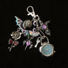 Silver and purple star-shaped keychain featuring a pocket watch and various charms.