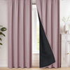 A pair of floor-length blackout curtains in mauve pink and black hanging in a window frame.