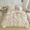 A light pink bohemian duvet cover set with quilted texture displayed on a bed against white paneled walls.