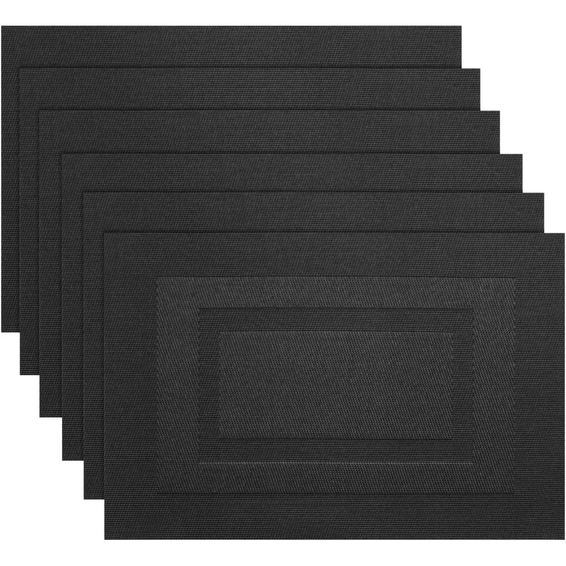 A set of six black non-slip heat resistant placemats stacked in a row.