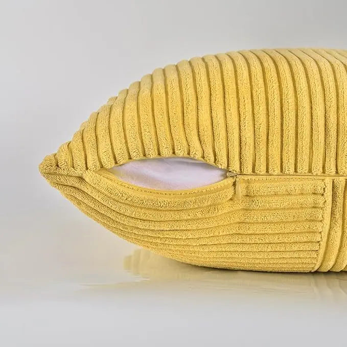A yellow retro corduroy patchwork pillow cover with a visible inner lining.