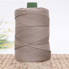 A spool of gray 3mm ice rope crochet yarn with a green cap resting on a woven mat.